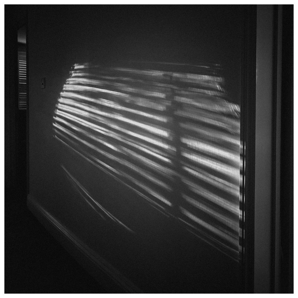 Reflection of a blind on a house internal wall